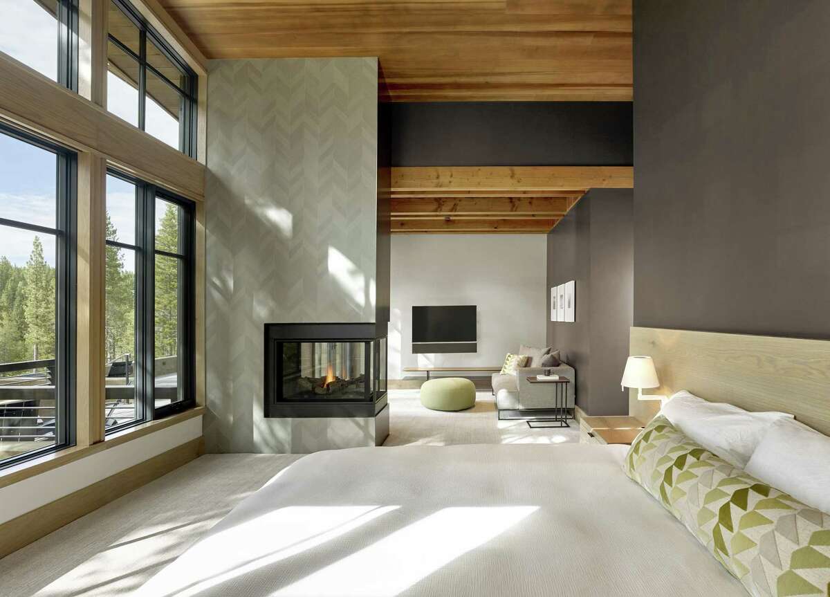 A three-sided gas fireplace warms this bedroom designed by San Francisco’s Y.A. Studio.