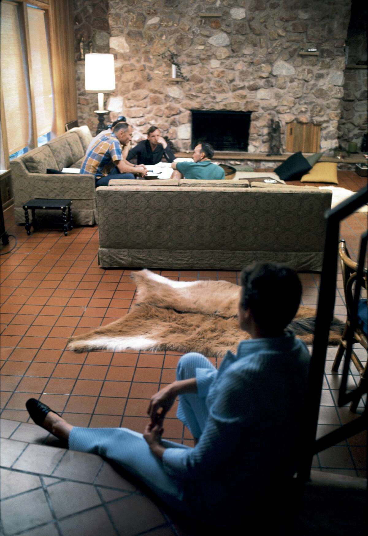 Neil Armstrong and his fellow Apollo 11 astronauts Buzz Aldrin & Michael Collins talk amongst themselves in the living room of the home in 1969.