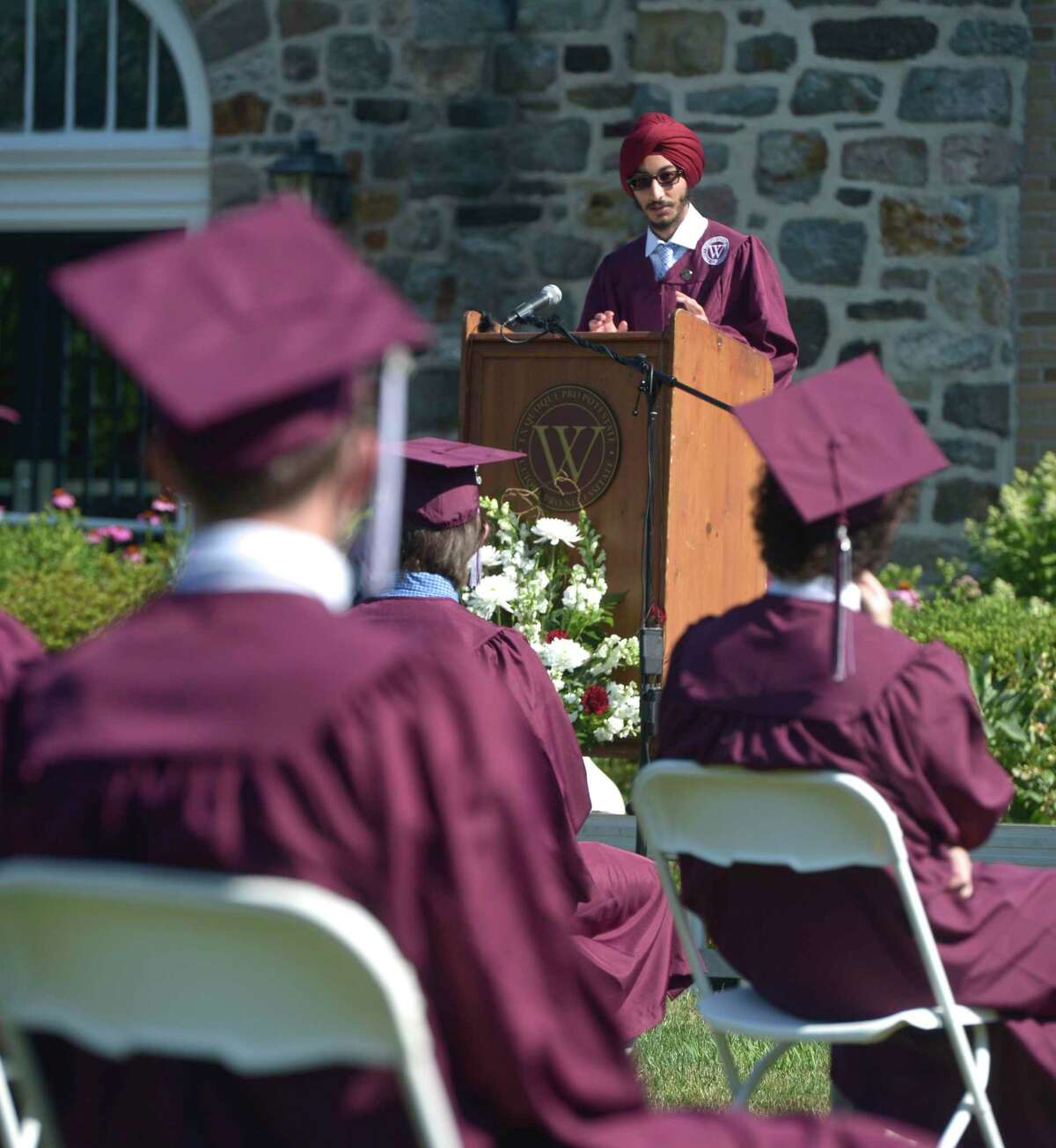 Sartaj Singh, class orator, gives his address during the Wooster School 2020 Commencement Exercises on Monday on the school campus in Danbury. Below, a grad laughs during Commencement.