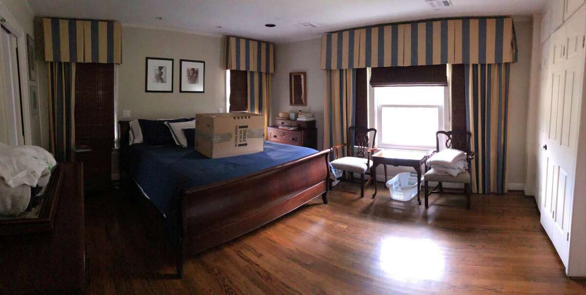 This "before" photo shows a dark bedroom with heavy window treatments.