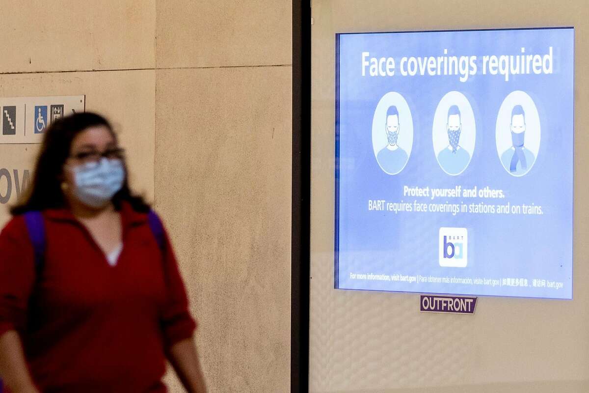 A sign reminds riders to wear face masks while waiting for their trains at Powell Street BART Station in in San Francisco, Calif. Friday, June 26, 2020. People returning to public transportation can expect mandatory face coverings for riders and operators, physical distancing markers and limited capacity on all vehicles. BART has a 15-step plan to welcome back riders that includes using hospital-grade disinfectant in stations and on-board trains, running longer cars to help promote social distancing, and offering personal hand straps for purchase that riders can take home and wash.