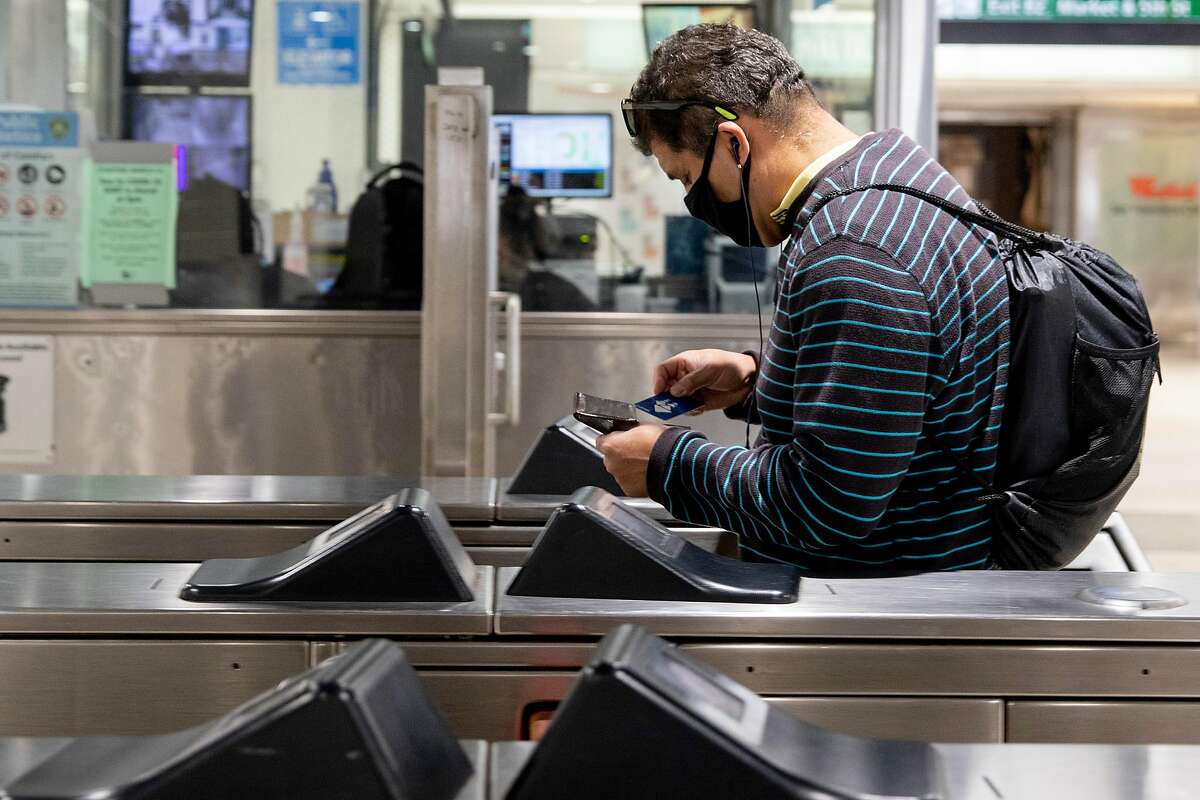 A rider wears a face mask while tapping their Clipper Card at Powell Street BART Station in in San Francisco, Calif. Friday, June 26, 2020. State Assemblyman David Chiu is re-introducing a bill that seeks to create an integrated public transportation system in the Bay Area and solve issues brought on by the fragmentation of the area’s various public transportation systems in an effort to increase ridership.