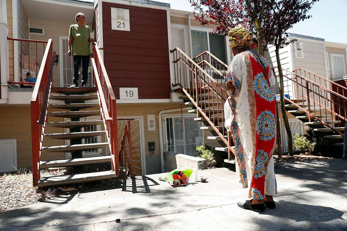 7月6日星期一，在加利福尼亚州旧金山惠特菲尔德法院，7月4日，6岁的杰斯·杨被枪杀，她的母亲阿萨勒-哈奎基亚·钱德勒(右)在现场献上鲜花并点燃蜡烛，默默地站在那里。