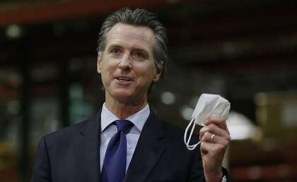 California Gov. Gavin Newsom displays a face mask as he urges people to wear them to fight the spread of the coronavirus during a news conference in Rancho Cordova on June 26.
