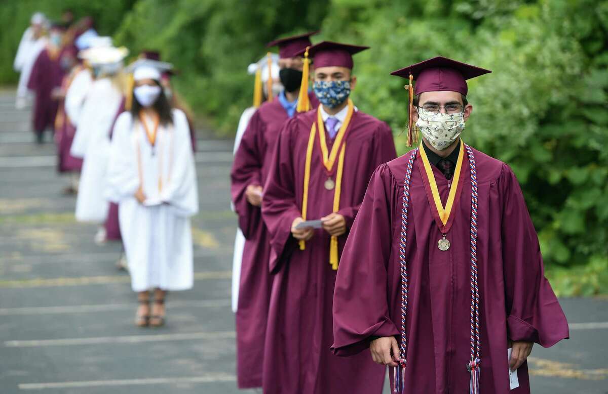 Graduates line up socially distant with face masks before crossing the stage and receiving their diplomas at the Sheehan High School graduation ceremony in the parking lot of the Toyota Oakdale Theatre in Wallingford on July 6, 2020. But because of the social distancing requirements associated with the coronavirus that forced Wallingford students to do online learning for the last three months of the school, the hope of traditional graduation disappeared. School officials polled the senior class weeks ago about their preferences for graduation, and holding the so-called “drive-in ceremony” at the Oakdale was the top choice. “It was so important to keep this in town,” Superintendent of Schools Salvatore Menzo Jr. said after the ceremony. Menzo said officials at Oakdale Theater, which is owned by concert promoter Live Nation, only charged the town “a really minimal amount” for the cost of the labor associated with setting up the parking lot for the event and providing security. Sheehan senior class President Grace Waldron recalled the day everything changed in the school district, March 12. That was when district officials announced classes would be going online and Waldron got the announcement in the midst of a college visit to Michigan as she got off the plane from Connecticut.  