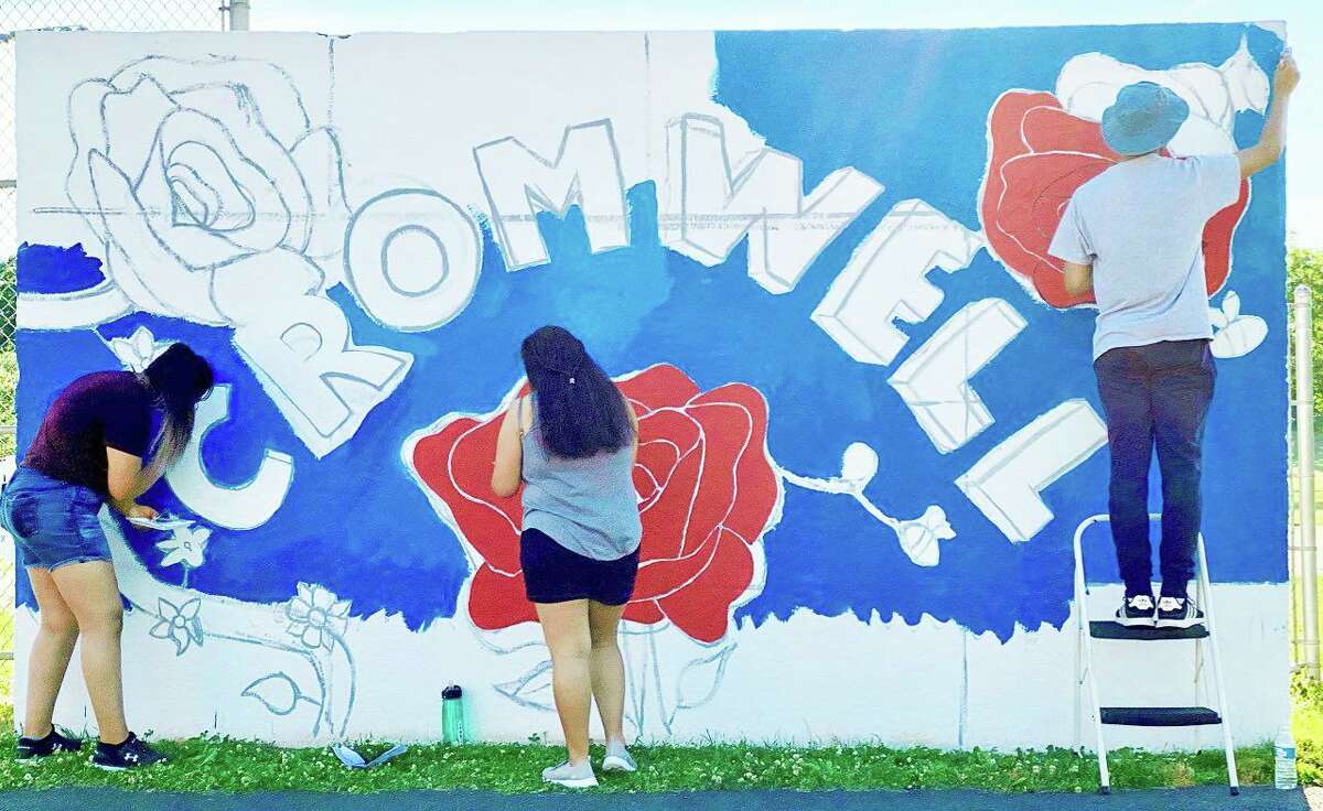 Cromwell Creative District and Cromwell High School’s National Arts Honor Society have teamed up to showcase the new dugout murals at Pierson Park. Shown here is the Celebrating Cromwell rose town mural: a work in process.