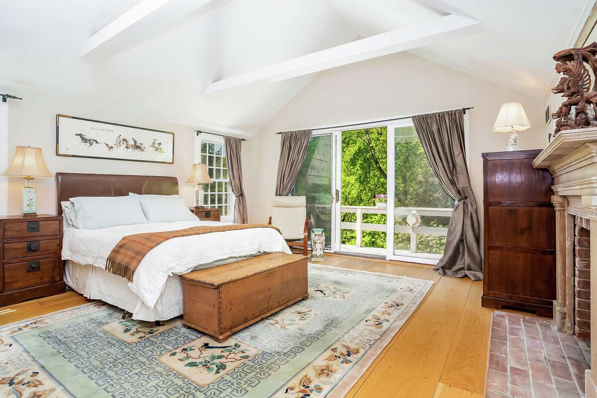 The master bedroom suite features a nine-foot vaulted ceiling, wood-burning fireplace, sliding doors to a private balcony/deck, and private bath. In the living room there is a stone fireplace. The spacious wood-paneled family room has an antique brick fireplace with a wood-burning stove insert, ceiling fan, and sliding doors to the expansive wrap-around deck that looks over the woodland setting beyond the 2.02-acre level property.