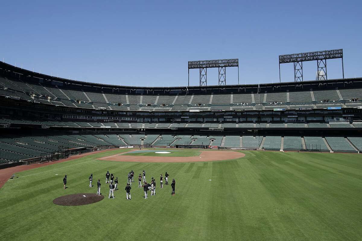 San Francisco Giants gather in the outfield at Oracle Park during a baseball practice in San Francisco, Sunday, July 5, 2020.