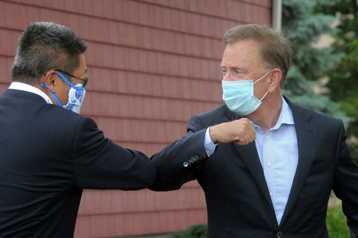 Gov. Ned Lamont bumps elbows with State Sen. Tony Hwang prior to a news conference on the University of Bridgeport campus, in Bridgeport, Conn. June 30, 2020.