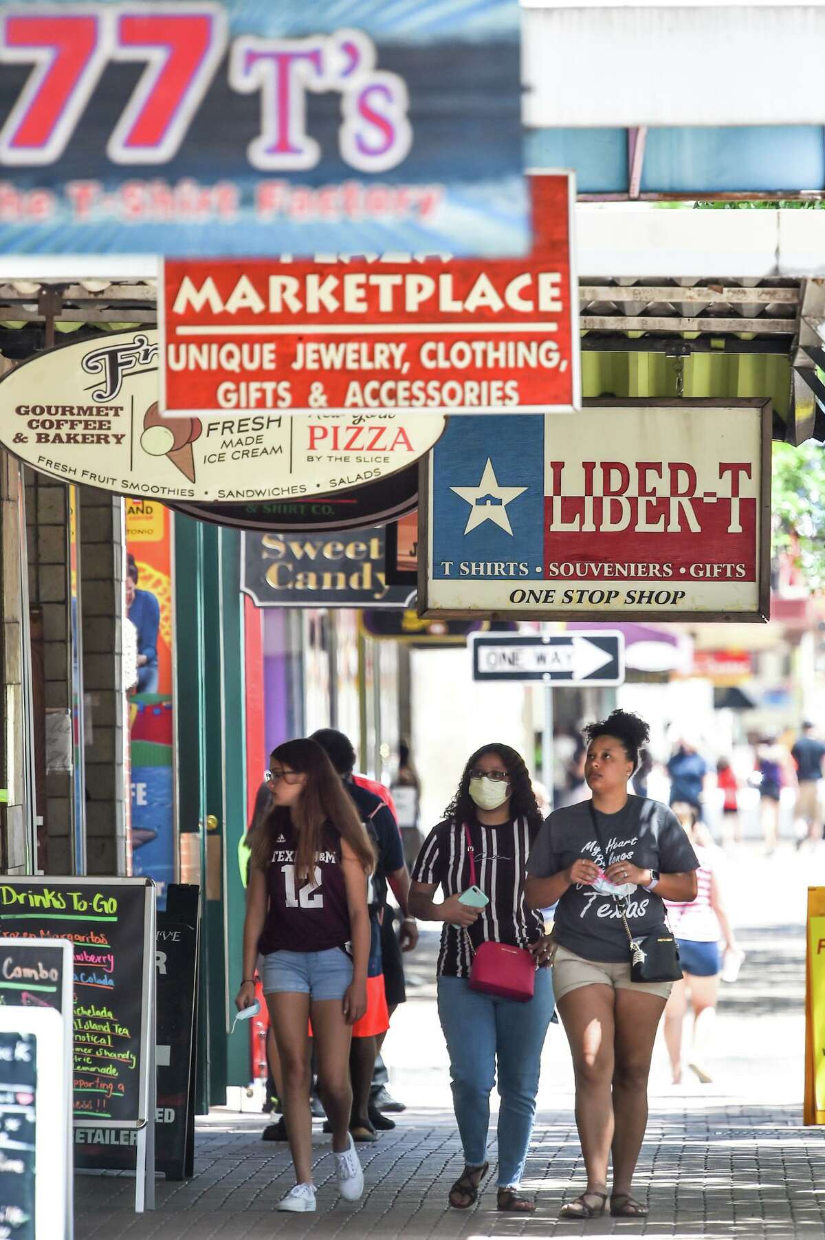Visitors walk along Alamo Street on the Fourth of July. “I can’t imagine a world where conventions don’t happen, where people don’t come to socialize with other people,” Thrailkill says. “But it’s not going to happen overnight.”