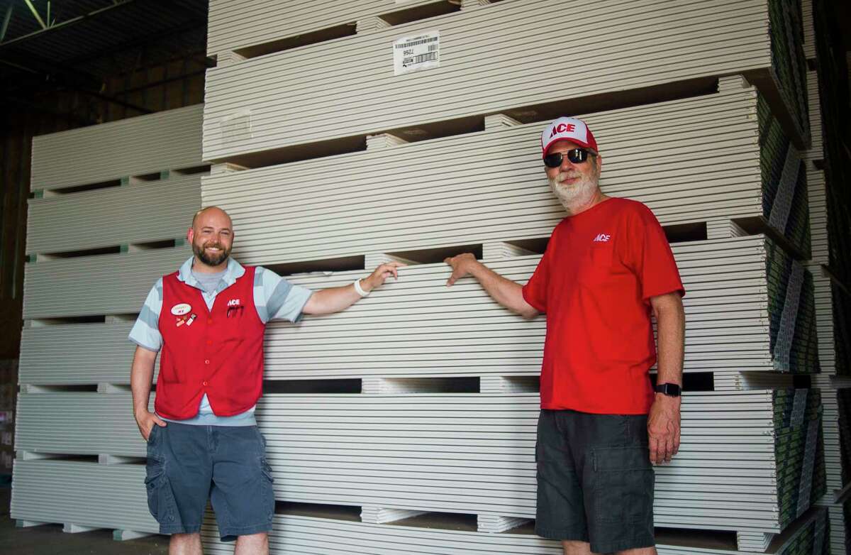 Daniel Buzzell, owner of Ace Hardware & Sports of Midland, left, and owner Greg White, right, stand in front of the 48,000 pounds of drywall which was donated to flood victims by Ace Hardware in partnership with USG Corporation, Tuesday inside J.E. Johnson's warehouse in Midland. From there, the United Way of Midland County will coordinate distribution to affected homes. (Katy Kildee/kkildee@mdn.net)