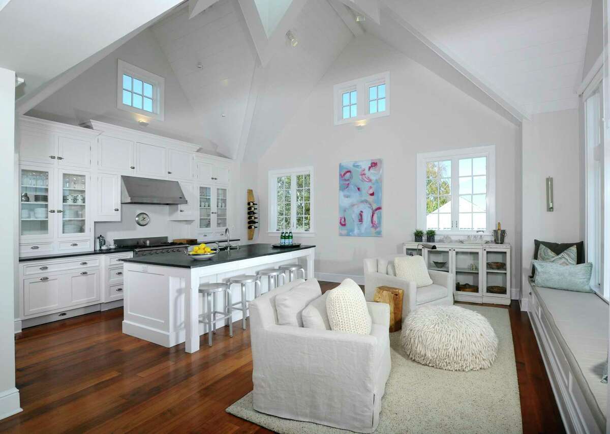 The spacious gourmet kitchen features a long center island/breakfast bar, two-story vaulted ceiling, high-end appliances, pantry, and a built-in window seat. On the first floor, or the lower level, there are three bedrooms and the family room. The master suite features a fireplace, sliding doors to a patio, a walk-in closet and another closet, and a spa-like private bath. One of the other bedrooms also has sliding doors to a separate patio. This house enjoys four patios including a sunken patio with a fire pit, and an outdoor shower, so as not to track beach sand into the house.
