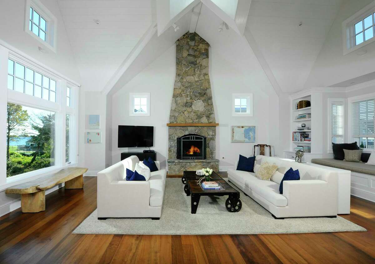 In the two-story great room there is a floor-to-ceiling stone fireplace, built-in bookshelves, and a built-in window seat. Also on the ground floor level there is a large family or recreation room with a stone fireplace and French doors that open up to one of the patios, and the private, level backyard. Privacy is protected by the strategic planting of tall shrubbery. This patio is bordered by a stone sitting wall. There is ample storage space on this lower level and access to the attached two-car garage.