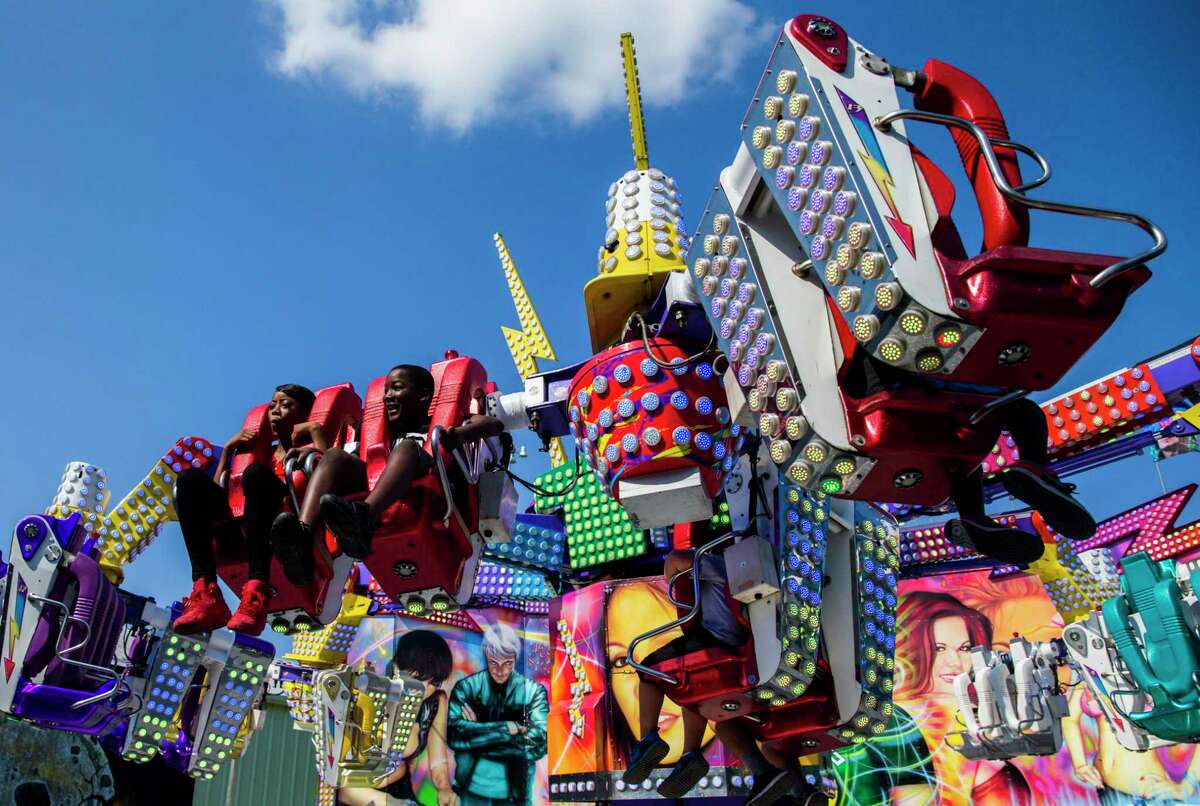 Shyanne Reynolds, 15, and Jersey Proctor, 12, ride a carnival ride in the midway at the State Fair of Texas in October 2019 at Fair Park in Dallas.