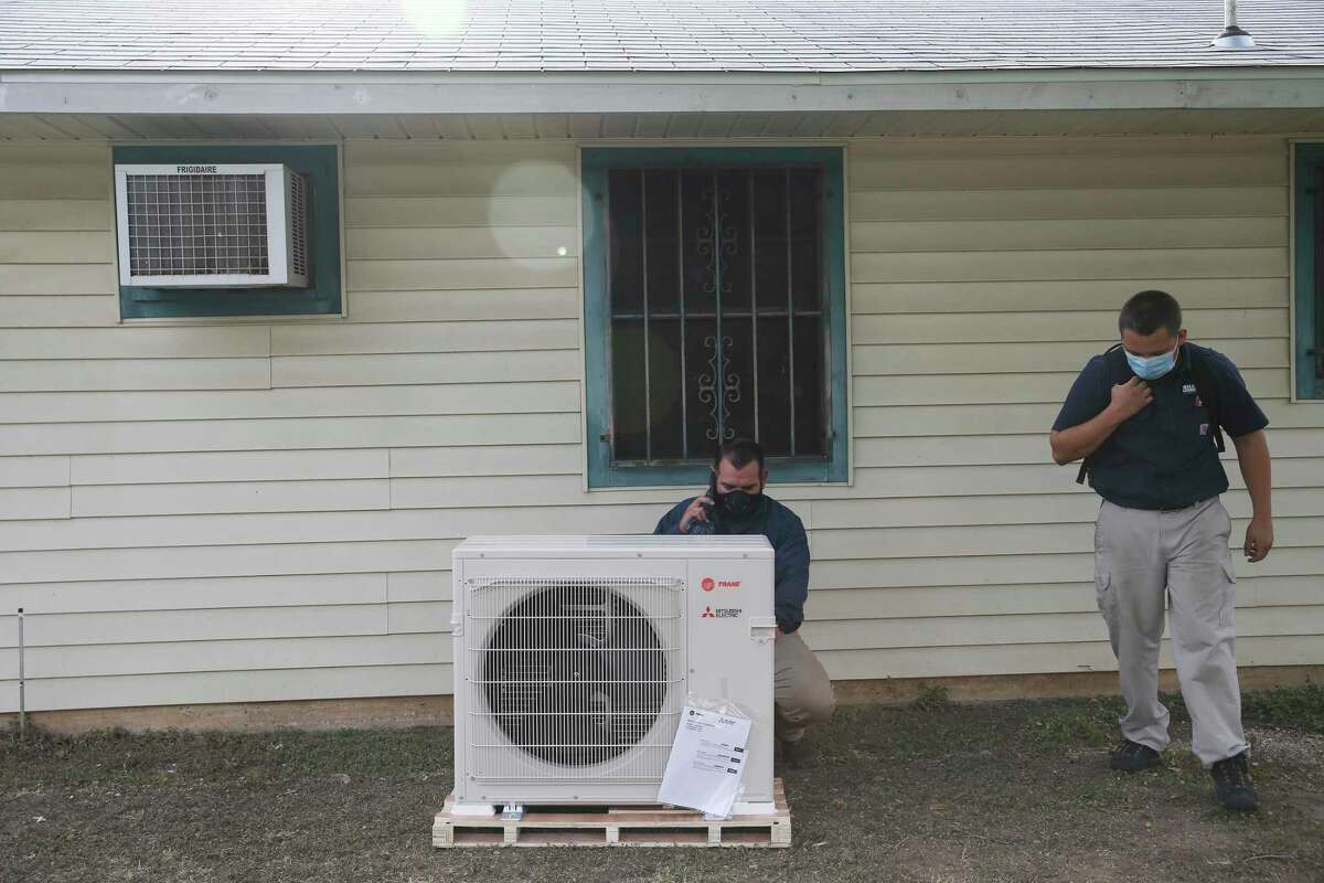 Derek Ramirez, left, and Eric Willitt with Shafer Service Plus work on installing a new AC system at the house of Yolanda Davis, Tuesday, July 7, 2020. The installation was done through the Boys and Girls Club of San Antonio's Together We Can Campaign. Her nieces, who live with her, attend the East Side Boys and Girls Club. Her sons, now adults, also were members of the club.