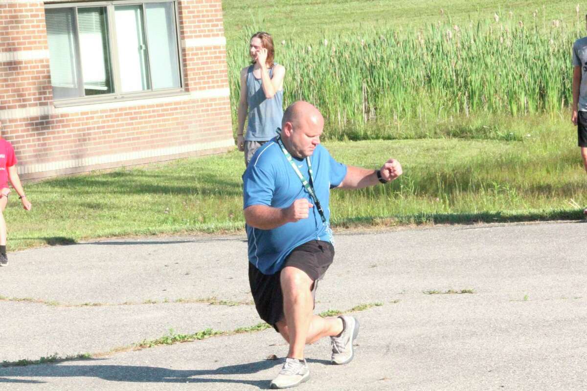 Reed City cross country coach Rich Saladin leads his runners through drills outside the middle school last week. (Herald Review photo/John Raffel)