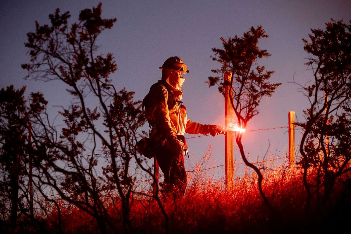 Firefighter Daniel Abarado lights a backfire while working to contain the Crews Fire from near Gilroy, Calif., on Sunday, July 5, 2020. (AP Photo/Noah Berger)