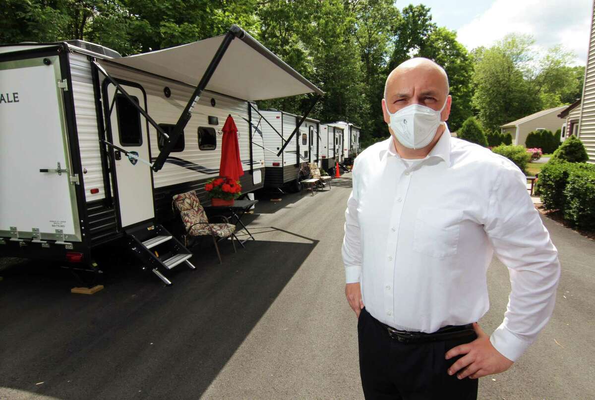 Tyson Belanger, who owns Shady Oaks Assisted Living, poses with some of the trailers he brought in for staff to live in at the facility in Bristol, Conn., on Thursday June 18, 2020. In March as the coronavirus spread through the state Belanger established a bubble at his facility, paying staff at great personal expense to stay full time at the residency.