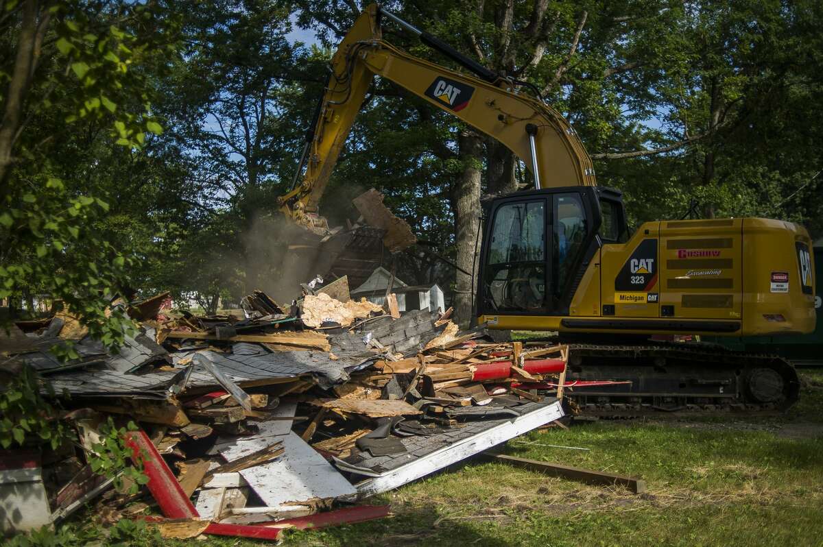 Penny Tyler's childhood home in Sanford, which was devastated by flooding, is demolished Wednesday, July 8, 2020 in preparation for a new home to be built free of cost thanks to Great Lakes Homes in Freeland. (Katy Kildee/kkildee@mdn.net)