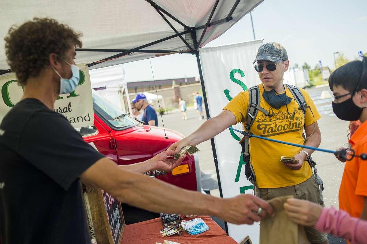 Customers peruse stalls at the Midland Area Farmers Market Wednesday, July 8, 2020 at its temporary location in the large parking lot next to Dow Diamond. (Katy Kildee/kkildee@mdn.net)