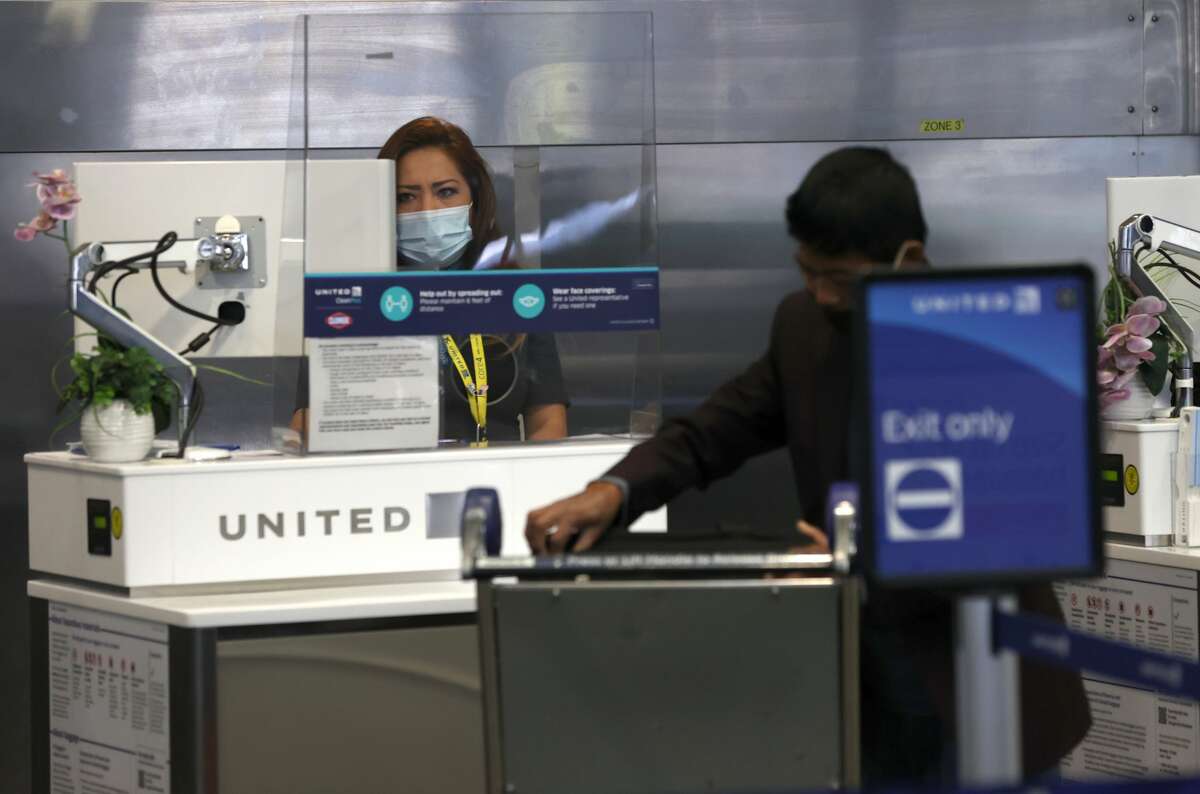 A United Airlines worker helps a customer at San Francisco International Airport on July 08, 2020 in San Francisco, California. As the coronavirus COVID-19 pandemic continues, United Airlines has sent layoff warnings to 36,000 of its front line employees to give them a 60 day notice that furloughs or pay cuts could occur after October 1.