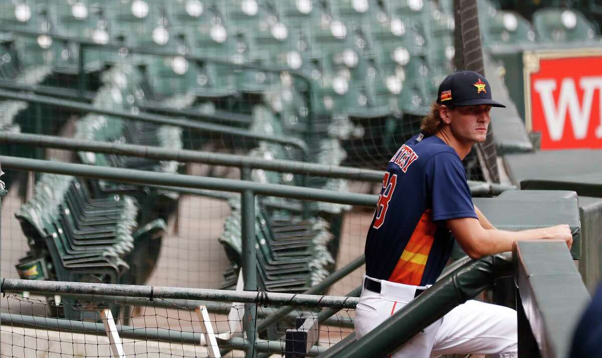 Houston Astros pitcher Forrest Whitley waits in the visitors dugout as he prepared to throw during the Astros summer camp at Minute Maid Park, Wednesday, July 8, 2020, in Houston.