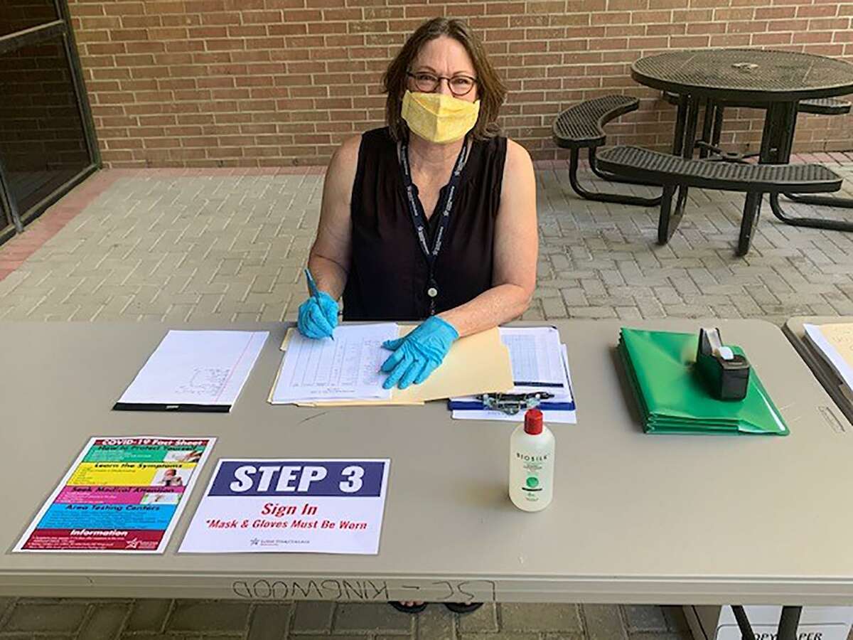 Angie Spargur, LSC-Kingwood Return to Building Coordinator, helping students and employees check in before entering the building. This coming semester, LSC plans to offer about half of its classes as online-only.