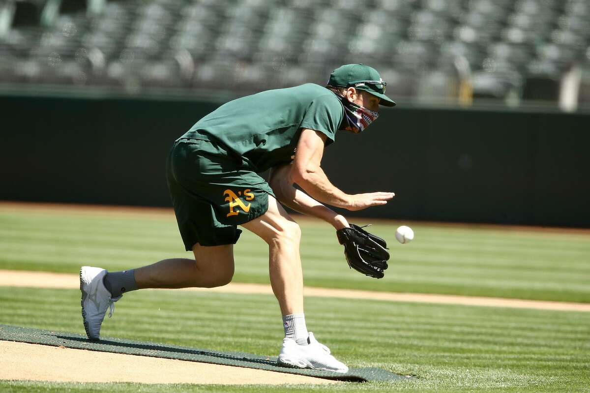 OAKLAND, CALIFORNIA - JULY 05: Chris Bassitt #40 of the Oakland Athletics fields a ground ball during summer workouts at RingCentral Coliseum on July 05, 2020 in Oakland, California. (Photo by Ezra Shaw/Getty Images)