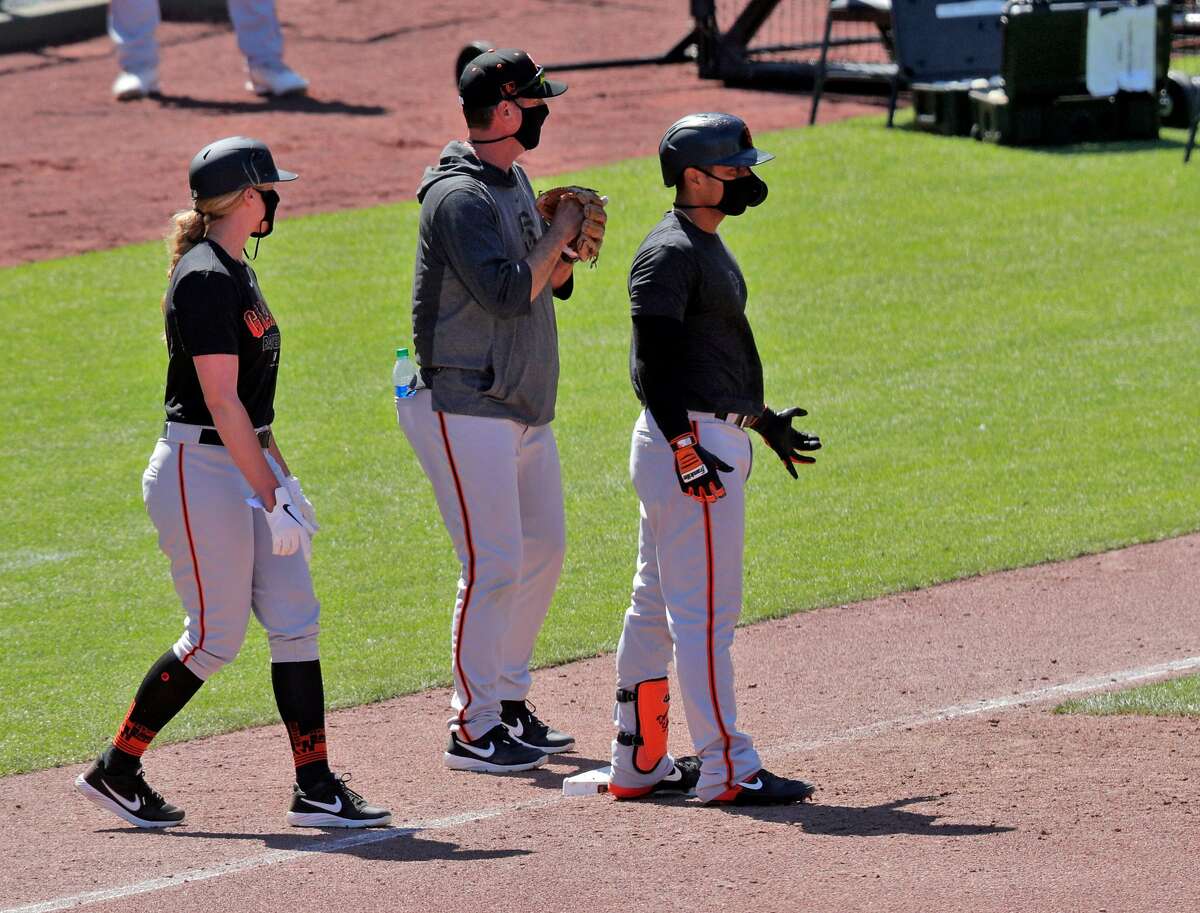 Alyssa Nakken, coaching first, approaches the runner as the San Francisco Giants worked out and played a simulated game at Oracle Park in San Francisco, Calif., on Wednesday, July 8, 2020.