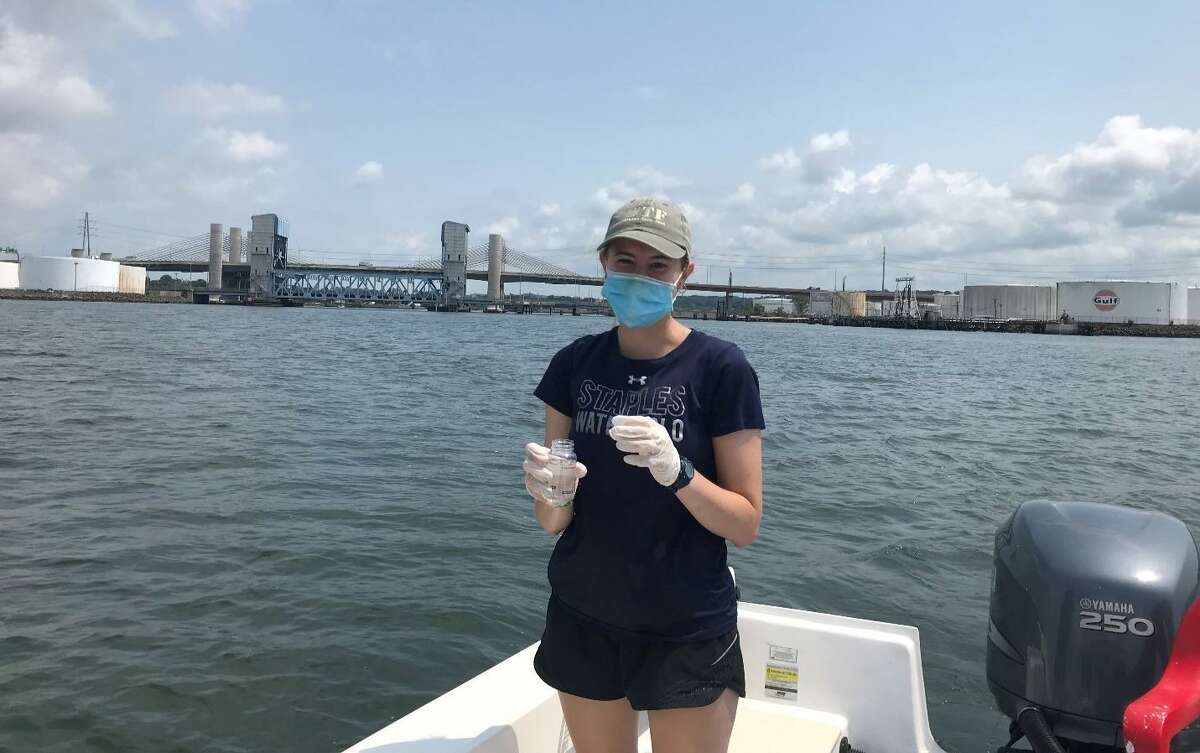 Save the Sound intern Teagan Smith collects water samples in New Haven Harbor with Soundkeeper Bill Lucey Wednesday.
