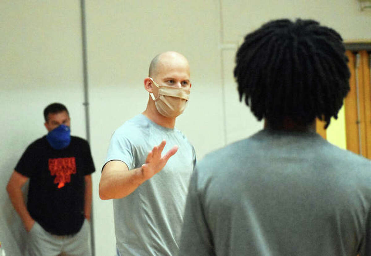 Edwardsville boys basketball coach Dustin Battas tells each member of his team to go get a mask before the start of practice Thursday.