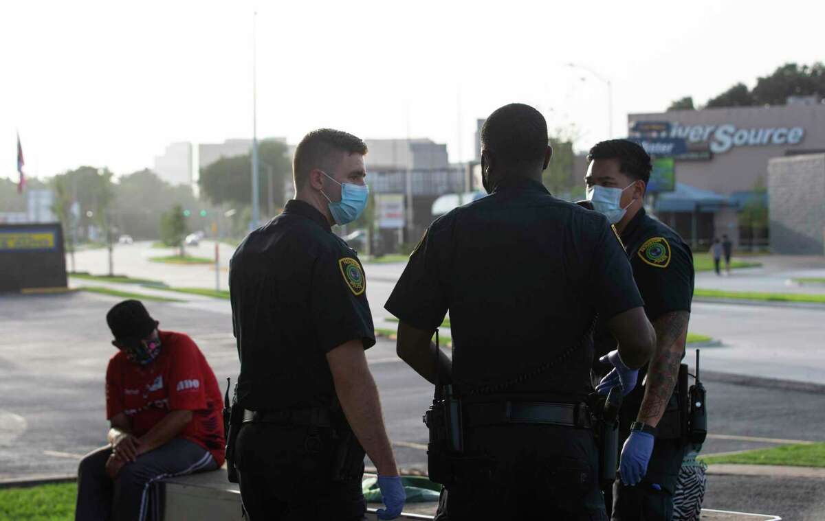 Houston Police Department Crisis Intervention Response Team Officer Richard Pietruszynski, left, talk to the officers who secured the scene where an individual has mental health issues Thursday, July 2, 2020, in Houston. The person, who has mental health history, had been drinking straight vodka for more than 12 hours when the police arrived the scene. In Houston and Harris County, social workers have been part of the police response for more than a decade, partnering with patrol officers to respond to mental health crises and domestic violence calls.