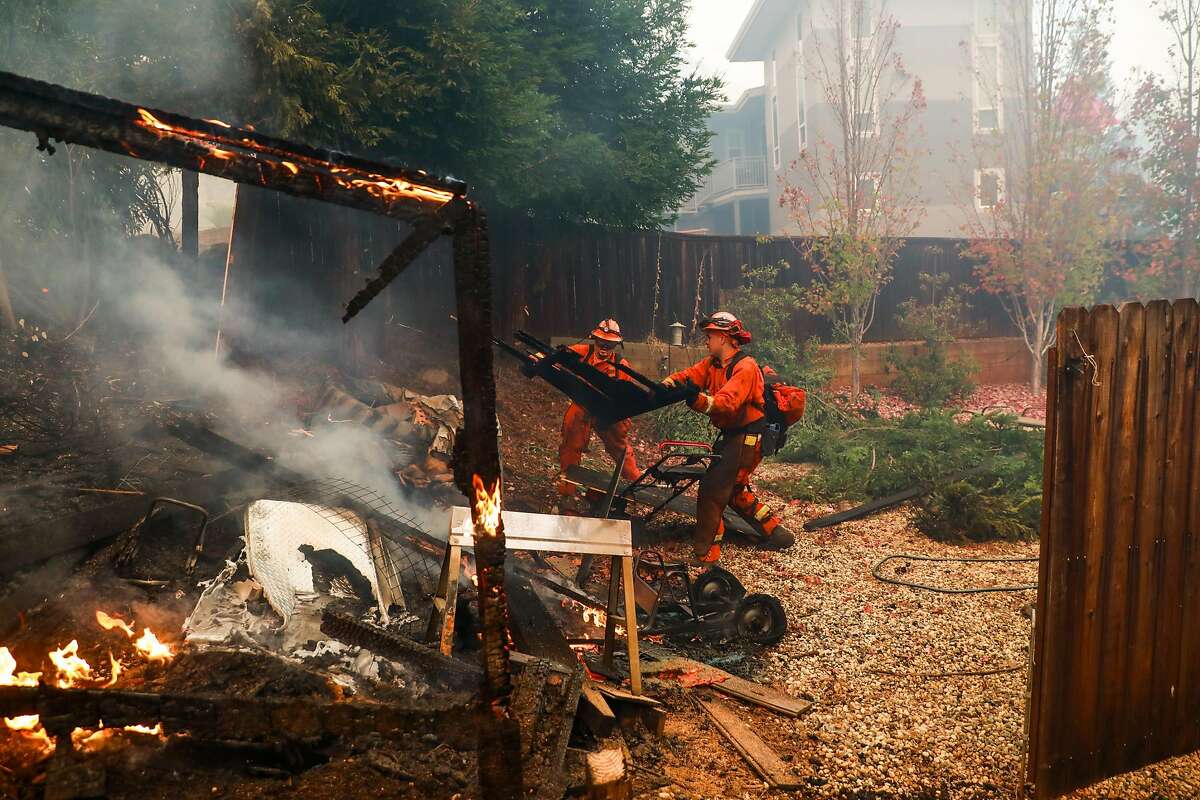 Inmate firefighters work to save a house off of Pentz Road during the Camp Fire in Paradise, California, on Thursday, Nov. 8, 2018.