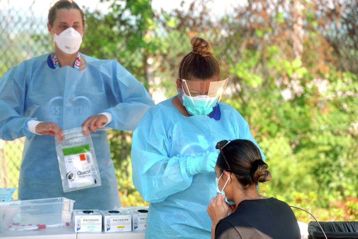 Hundreds of people turned out Thursday morning for COVID-19 tests at Liberation Programs, in Bridgeport, Conn. July 9, 2020. The free community Coronavirus test screenings were administered by the staff of Bridgeport's Southwest Community Health Center.