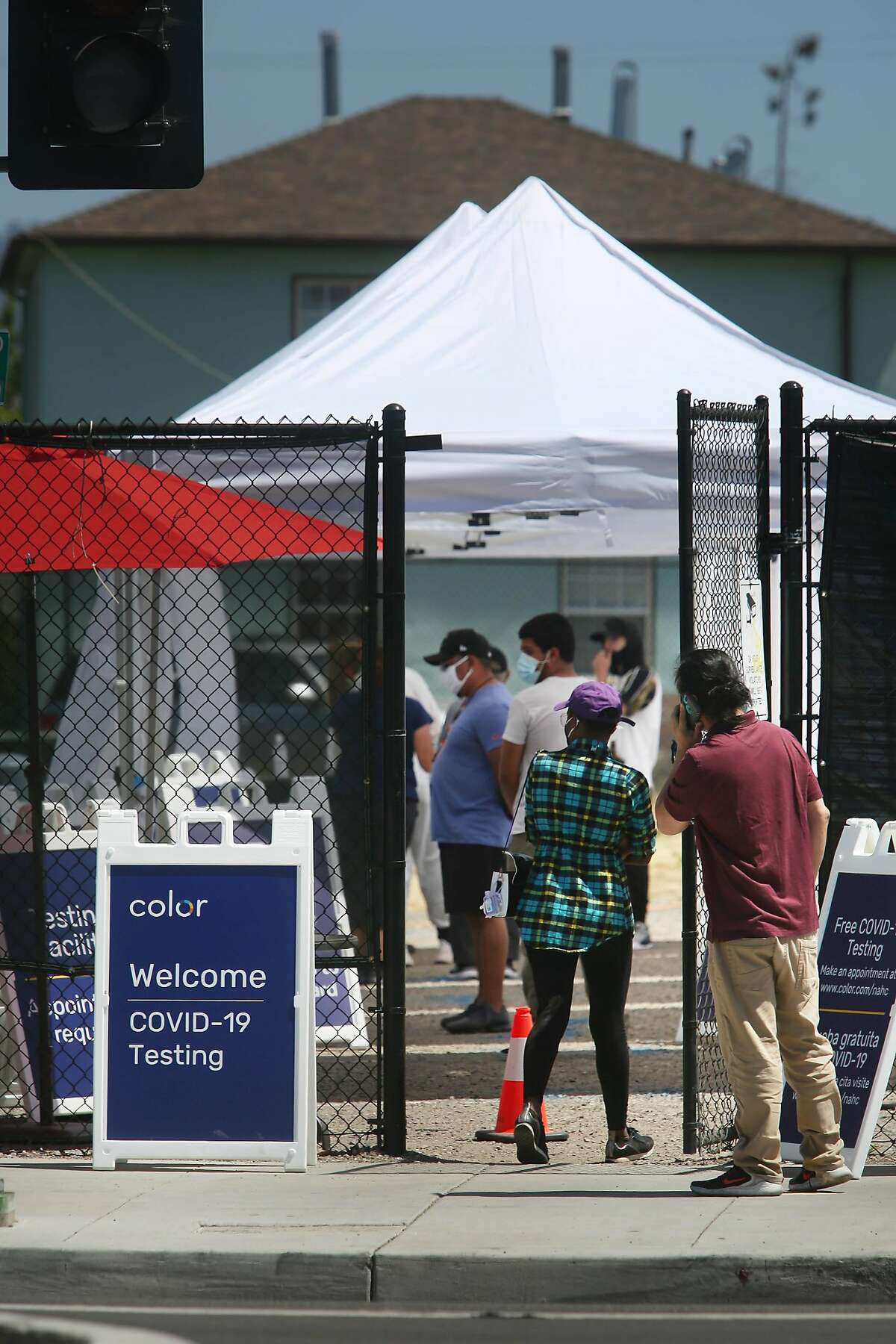 People line up for testing at the COVID-19 testing site at the Native American Health Center on Thursday, July 9, 2020 in Oakland, Calif.