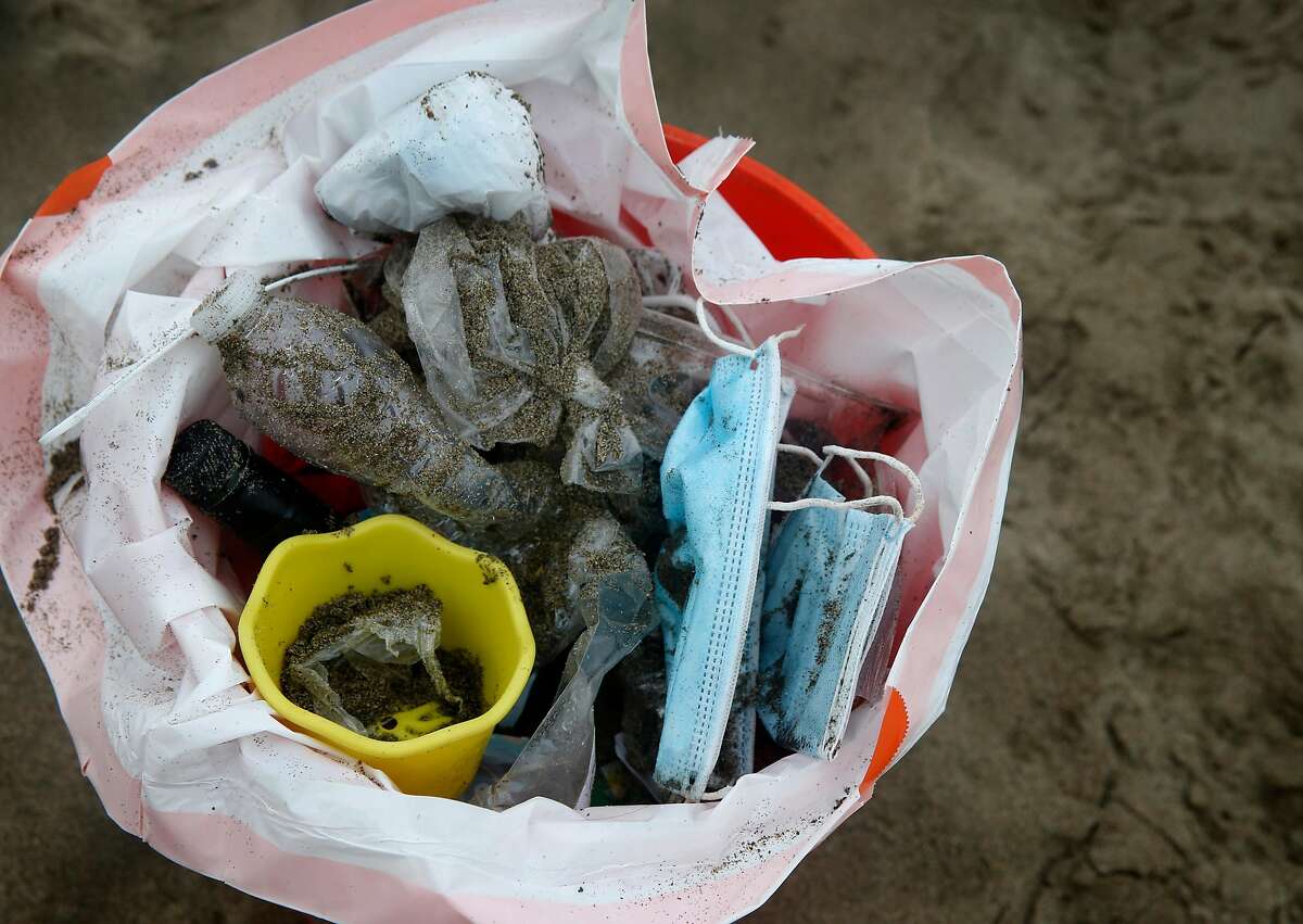 Used face masks, plastics and other debris is collected from Baker Beach by Eva Holman and other volunteers in San Francisco, Calif. on Tuesday, June 23, 2020.