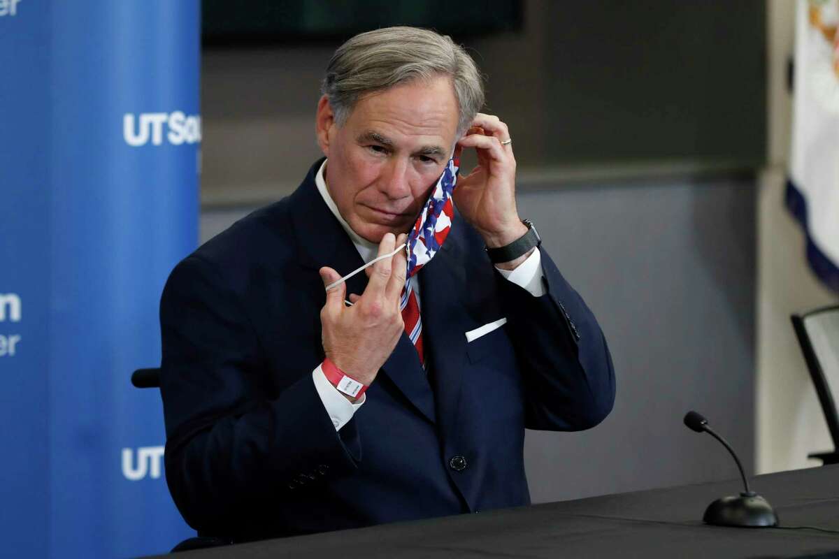 Texas Gov. Greg Abbott puts on a mask after a news conference following a meeting between Vice President Mike Pence, Abbott and members of his healthcare team regarding COVID-19 at the University of Texas Southwestern Medical Center West Campus in Dallas, Sunday, June 28, 2020. (AP Photo/Tony Gutierrez)
