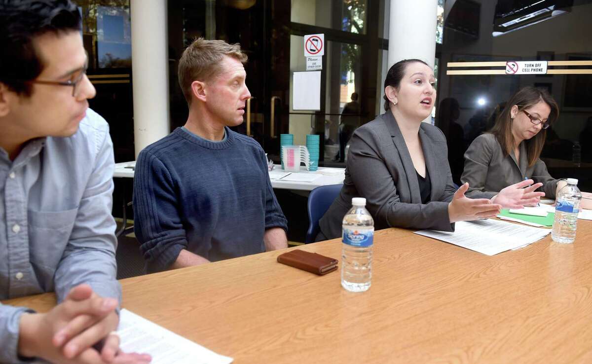 Left to right, Melvin Medina, Advocacy and Outreach Director for the ACLU of Connecticut, and Dan Barrett, Legal Director of the ACLU of Connecticut, listen to attorney Ellen Messali of New Haven Legal Assistance speak about how to interact with police during a discussion at the Consulate General of Ecuador in New Haven in 2016. At right is Cristina Velasquez acting as an interpreter.