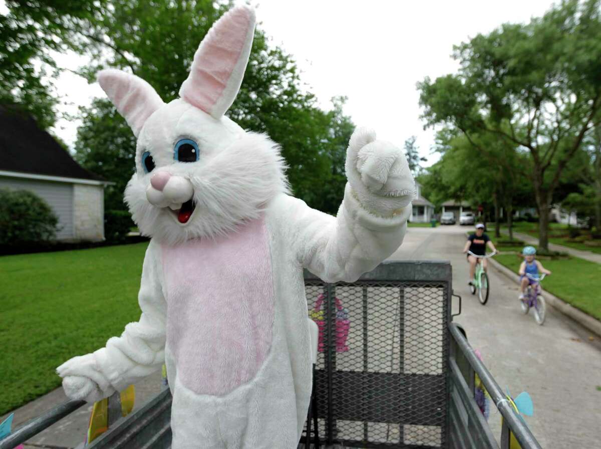 Michael Bisbee, dressed as the Easter Bunny, dances as a family rides beside him as his family drives around neighborhoods in The Woodlands to spread some Easter joy, Friday, April 10, 2020. Bisbee, 55, passed away unexpectedly on Monday.