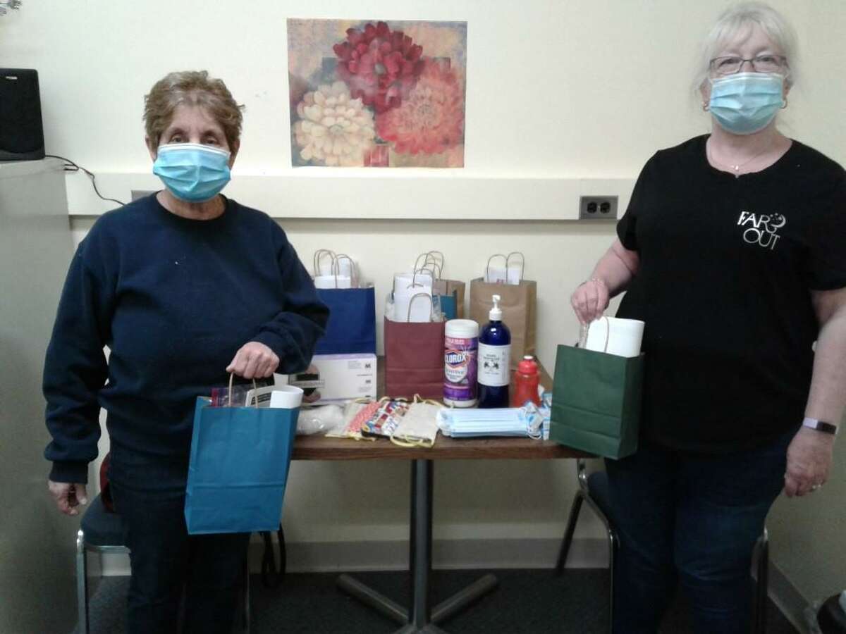 Caregivers Margaret Mobilia, left, and Karen Bertrand distribute PPE to essential workers and discuss safety protocols for COVID-19.