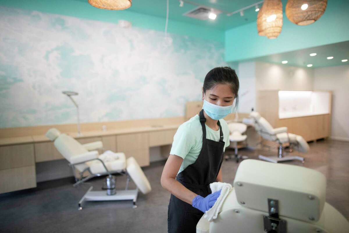 FaceHaus in Rice Village lead aesthetician Angie Duong, 37, cleans up her station on Wednesday, July 1, 2020, in Houston, as part of the safest precautions because of COVID-19.