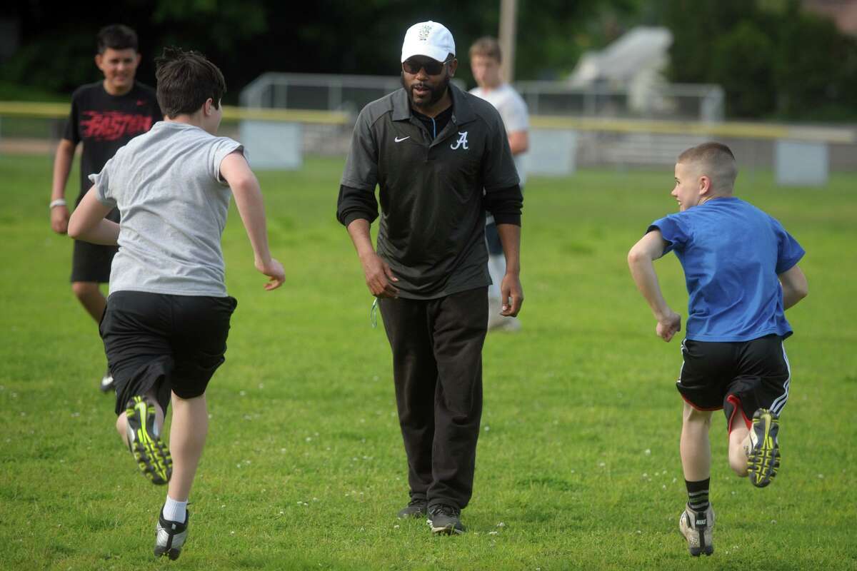 Kente Douglas leads players through an early practice for the Pop Warner football team he helps coach in Ansonia, Conn. May 22, 2019.