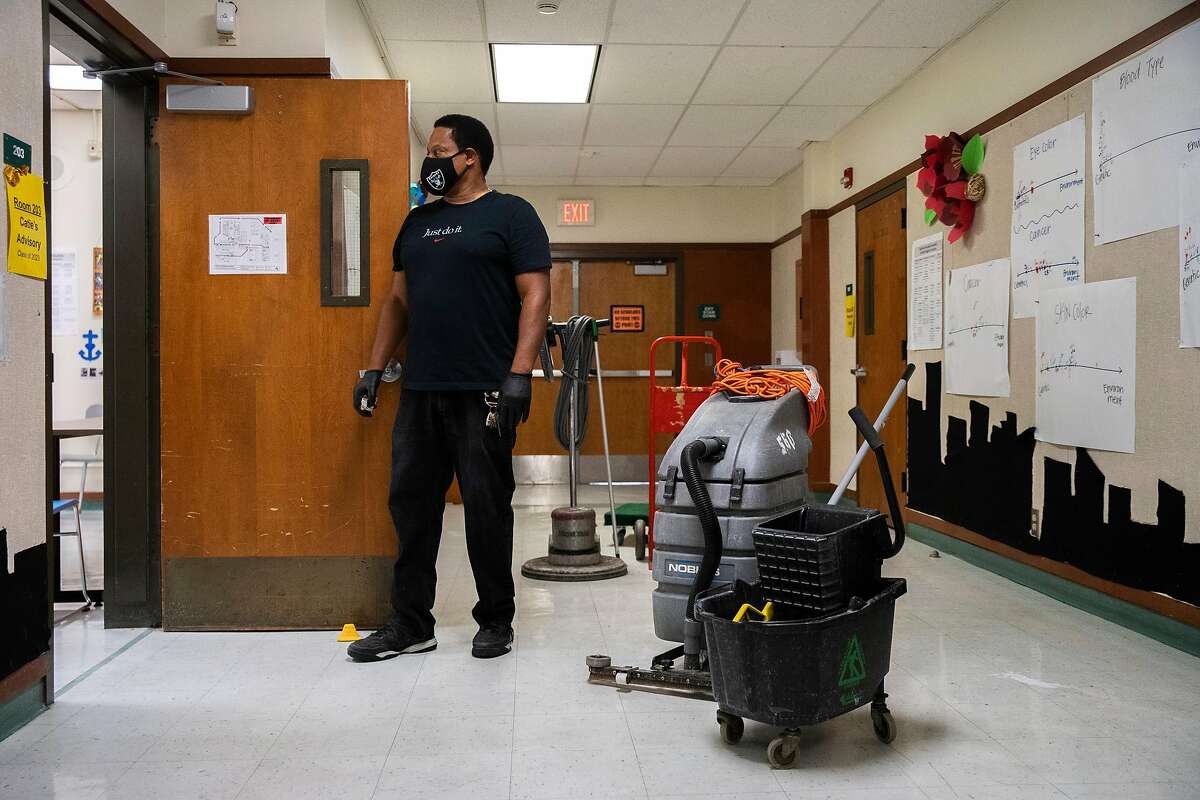 Philip Elliott, the supervising custodian, checks one of the classrooms that's set up for physical distancing at Westlake Middle School on Friday, July 10, 2020, in Oakland, Calif.