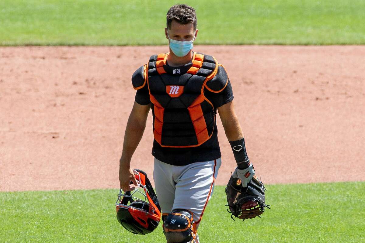 2020年7月4日星期六，旧金山巨人队在加州旧金山甲骨文公园举行夏季训练营，捕手巴斯特·波西戴着口罩在主场后面站位。由于新型冠状病毒感染症(COVID-19病毒)，美国职业棒球大联盟(MLB)的2020赛季被推迟，球员们戴着口罩，保持距离，开始热身和训练。