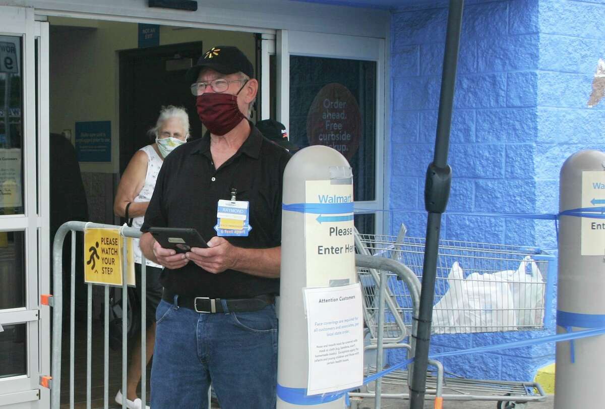 Walmart Health Ambassador Raymond Haight informs customers of the new face mask regulations Friday outside the front entrance to the Walmart in Big Rapids. (Pioneer photo/Cathie Crew)