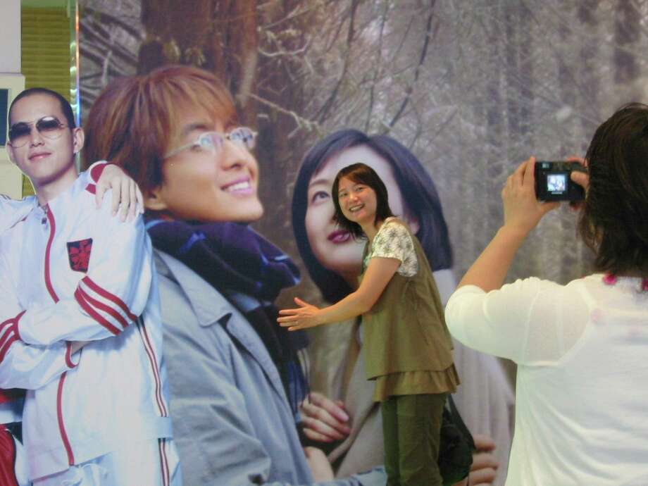 Midori Mizoguchi, a Japanese tourist, takes a photo of her sister Yumi Yamada at the Korean Entertainment Hall of Fame. The were on a three day, two-night tour of soap opera filming sites in South Korea. Photo: Vanessa Hua /San Francisco Chronicle / Chronicle