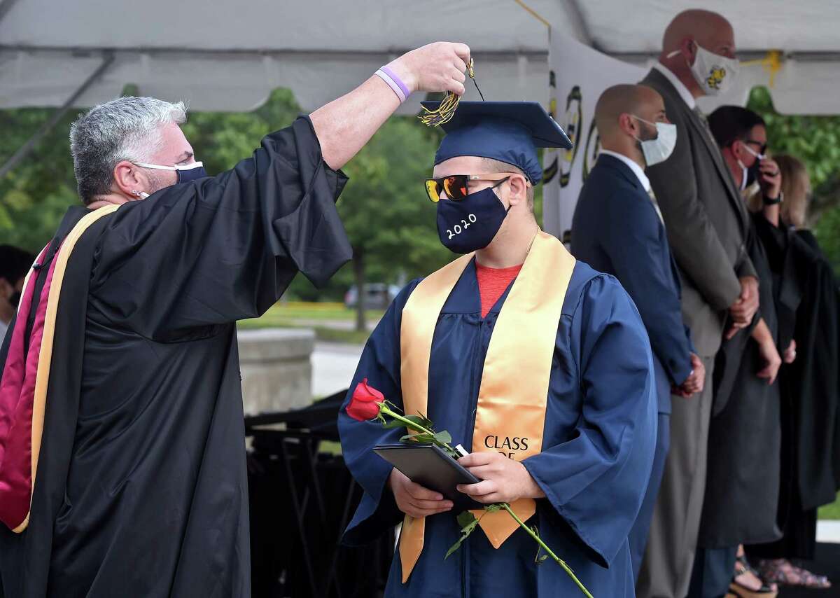 Vincenzo Bunce gets assistance with his tassel from Dean of Students Mark Hughes during the East Haven High School graduation ceremony in front of the school on July 11, 2020.