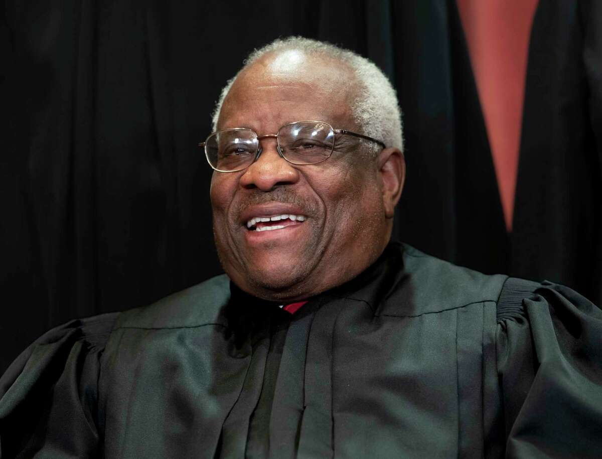 FIILE - In this Nov. 30, 2018, file photo, Supreme Court Associate Justice Clarence Thomas, appointed by President George H. W. Bush, sits with fellow Supreme Court justices for a group portrait at the Supreme Court Building in Washington. Thomas is now the longest-serving member of a court that has recently gotten more conservative, putting him in a unique and potentially powerful position, and heas said he isnat going away anytime soon. With President Donald Trumpas nominees Neil Gorsuch and Brett Kavanaugh now on the court, conservatives are firmly in control as the justices take on divisive issues such as abortion, gun control and LGBT rights. (AP Photo/J. Scott Applewhite, File)