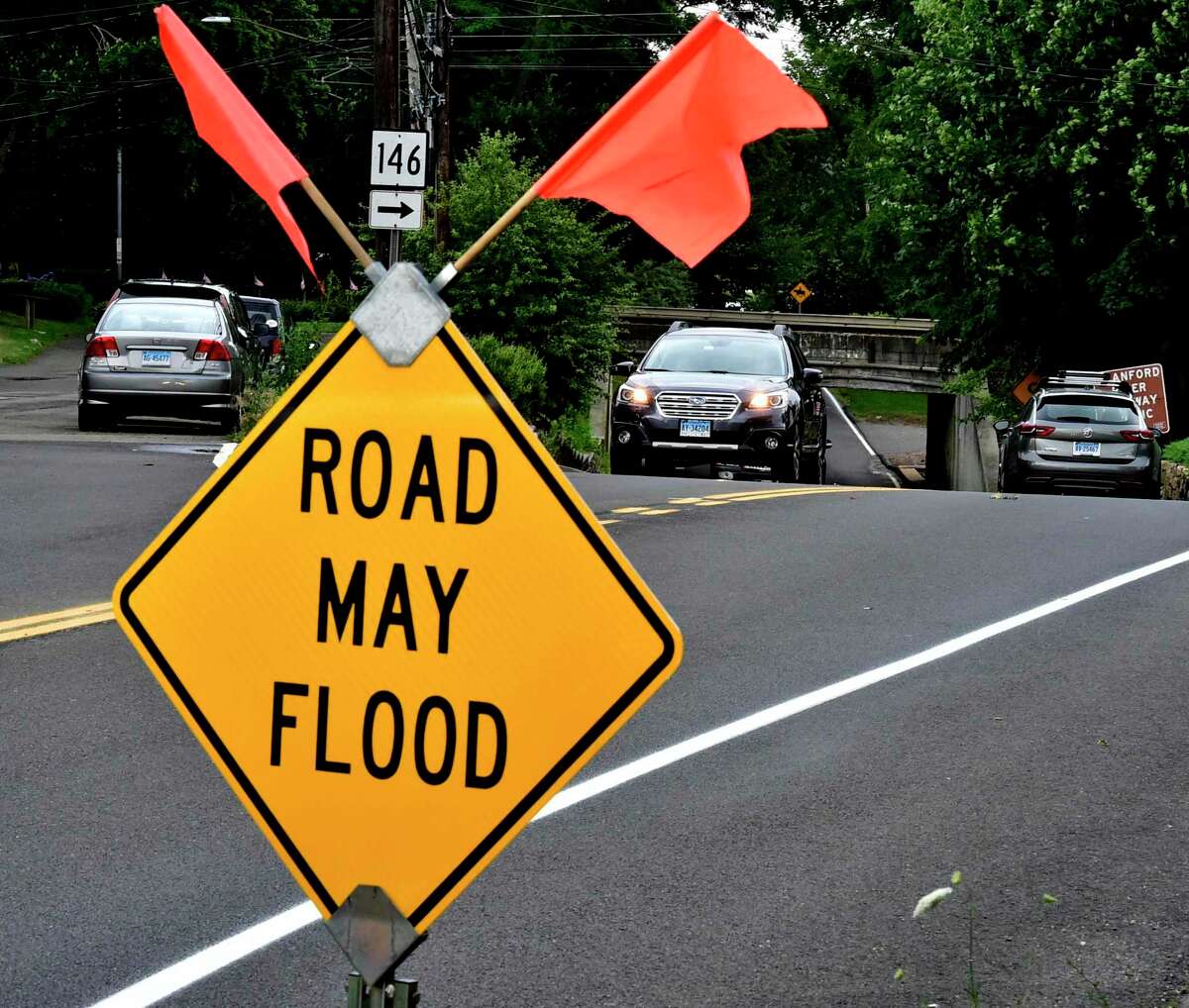File photo showing a sign that warns motorists that Montowese Street near Pine Orchard Road in Branford, Conn., may flood underneath a railroad underpass.