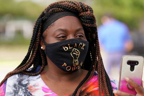 Mary Courtney takes a video during a protest about a Black Lives Matter billboard in parking lot at 11107 Bellaire Blvd. Saturday, July 11, 2020, in Houston. The Vietnamese Community of Houston and Vicinity organization had scheduled a protest and forum at the site.